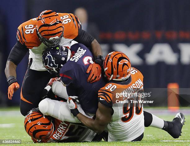 Tom Savage of the Houston Texans is tackled behind the line of scrimmage by Wallace Gilberry, Michael Johnson, and Carlos Dunlap of the Cincinnati...