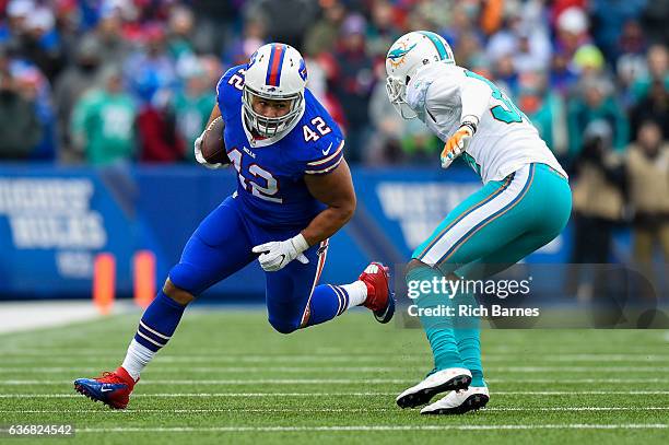 Jerome Felton of the Buffalo Bills runs with the ball as Tony Lippett of the Miami Dolphins defends during the first quarter at New Era Field on...