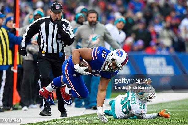 Jerome Felton of the Buffalo Bills gets upended by Tony Lippett of the Miami Dolphins during the first quarter at New Era Field on December 24, 2016...