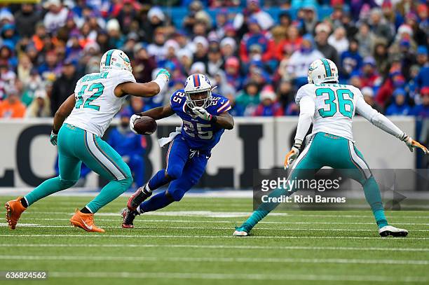 LeSean McCoy of the Buffalo Bills runs with the ball between Spencer Paysinger and Tony Lippett of the Miami Dolphins during the second quarter at...