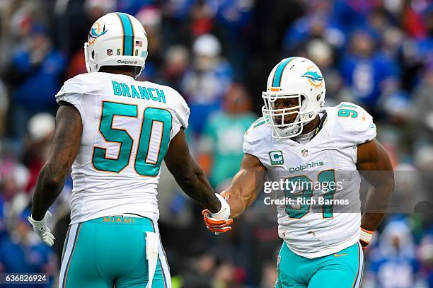 Andre Branch of the Miami Dolphins shakes hands with Cameron Wake following his sack against the Buffalo Bills during the second quarter at New Era...