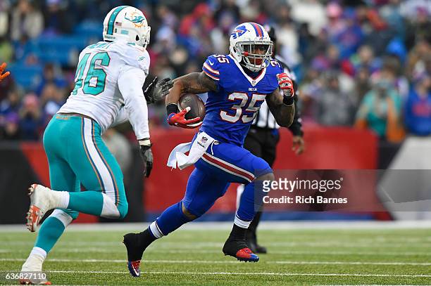 Mike Gillislee of the Buffalo Bills runs with the ball as Neville Hewitt of the Miami Dolphins defends during the third quarter at New Era Field on...
