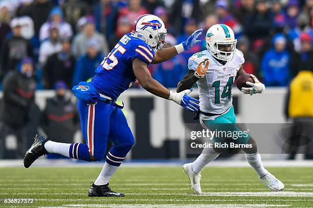 Jarvis Landry of the Miami Dolphins runs with the ball as Jerry Hughes of the Buffalo Bills defends during the fourth quarter at New Era Field on...