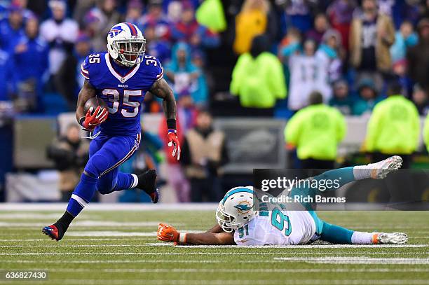 Mike Gillislee of the Buffalo Bills runs with the ball past Cameron Wake of the Miami Dolphins tackle attempt during overtime at New Era Field on...
