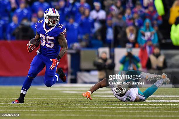 Mike Gillislee of the Buffalo Bills runs with the ball past Cameron Wake of the Miami Dolphins during overtime at New Era Field on December 24, 2016...