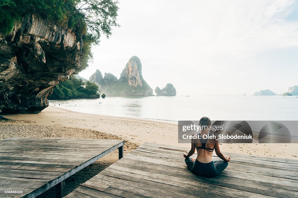 Woman doing yoga on the beach