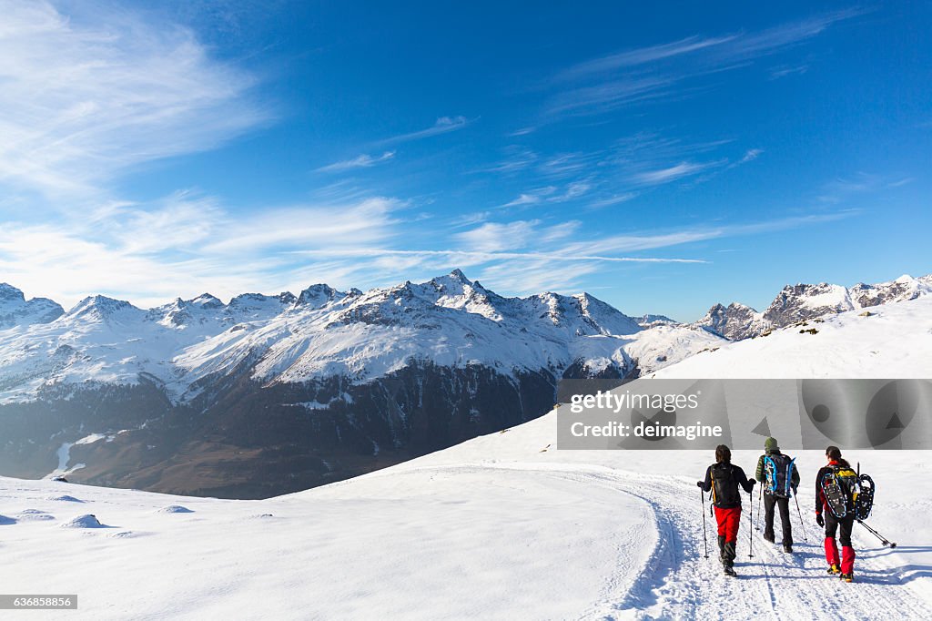 Wanderer wandern auf schneebedeckter Straße im Hochgebirge