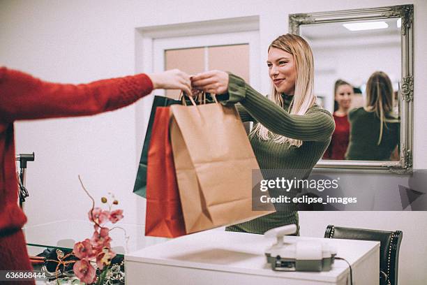 young woman with shopping bag in clothing store - clothes shop counter stock pictures, royalty-free photos & images