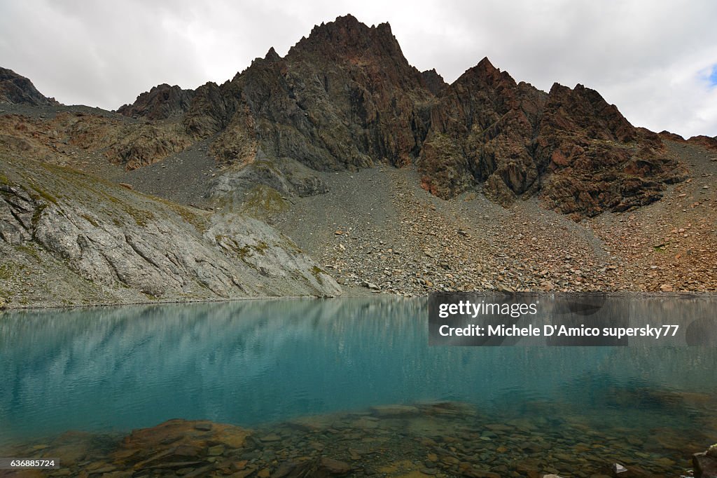 Alpine blue lake surrounded by barren rocky landscape.