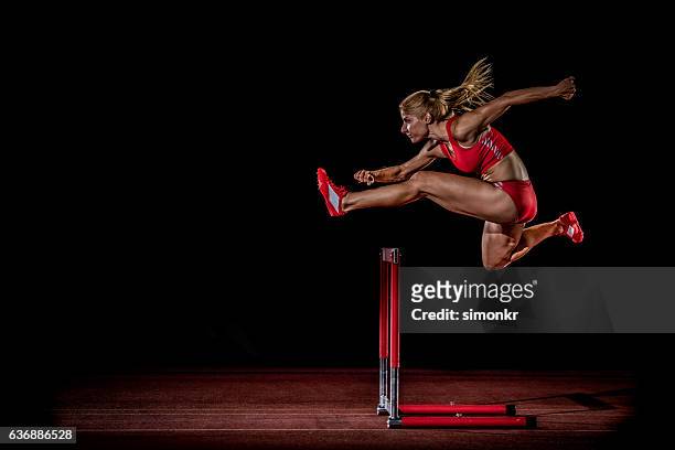 athlete clearing hurdle - hurdling track event 個照片及圖片檔