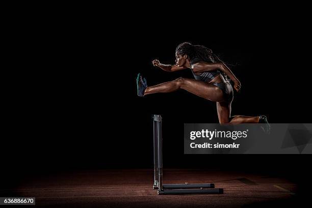 athlete clearing hurdle - hurdle stock pictures, royalty-free photos & images
