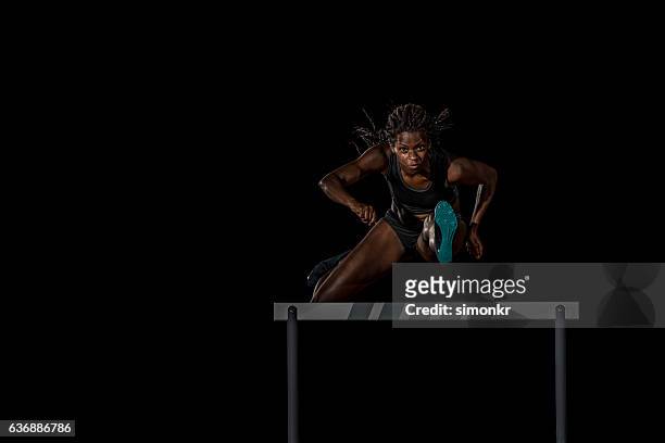 athleten räumen hürde - woman long jump stock-fotos und bilder
