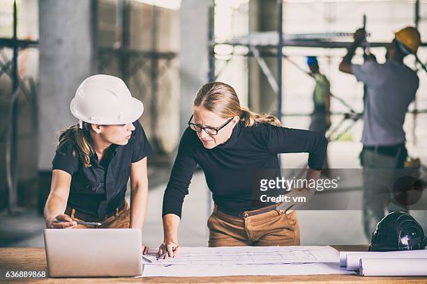 female construction worker consulting an architect - architecture woman stockfoto's en -beelden