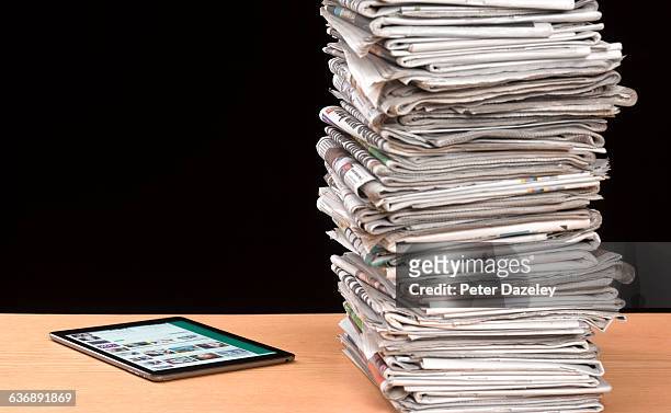 stack of newspapers with tablet - england media access foto e immagini stock