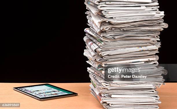 stack of newspapers with tablet - england media access stockfoto's en -beelden