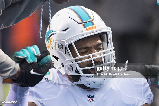 Trainers help Spencer Paysinger of the Miami Dolphins to his feet during the second half against the Buffalo Bills on December 24, 2016 at New Era...