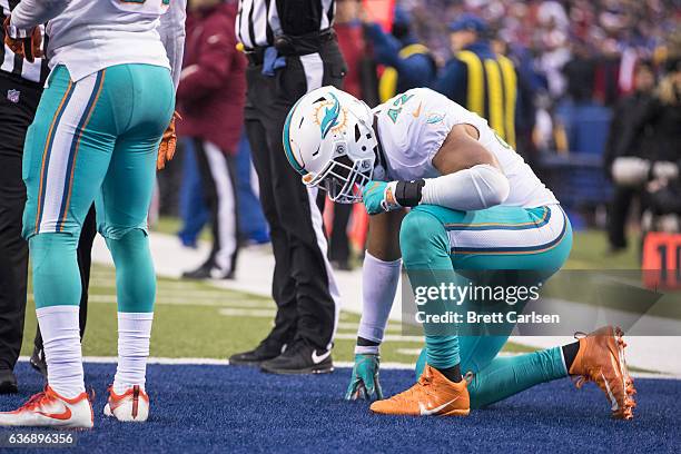 Spencer Paysinger of the Miami Dolphins drops to a knee after being shaken up on the previous play during the second half against the Buffalo Bills...