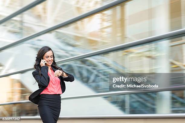 hispanic business women on phone walking in a rush - woman hurry 個照片及圖片檔