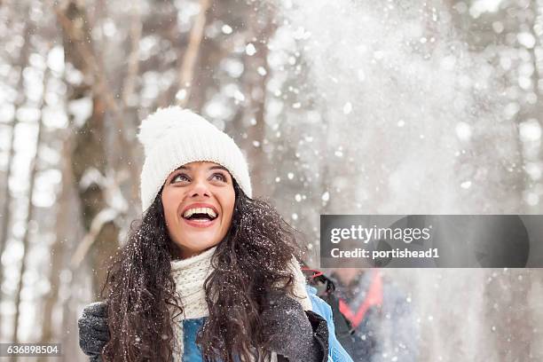 cheerful young woman having fun in the snow forest - snow fun stock pictures, royalty-free photos & images