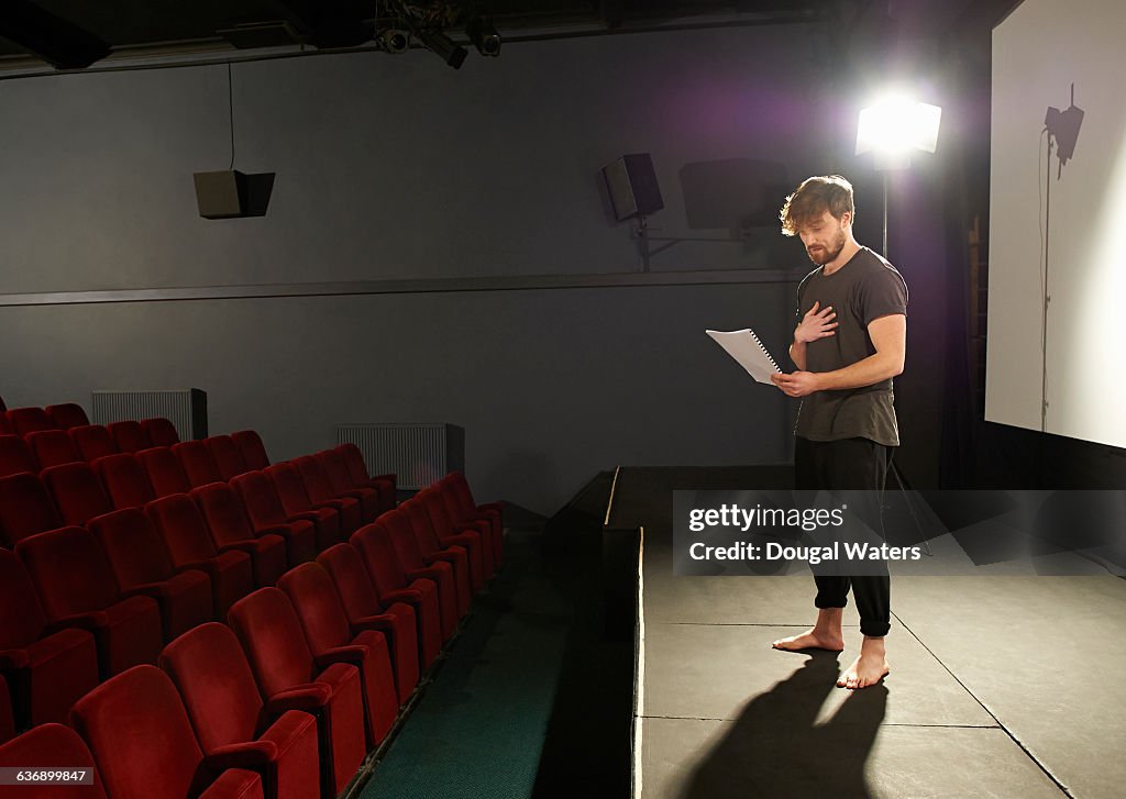 Actor rehearsing his lines on stage.