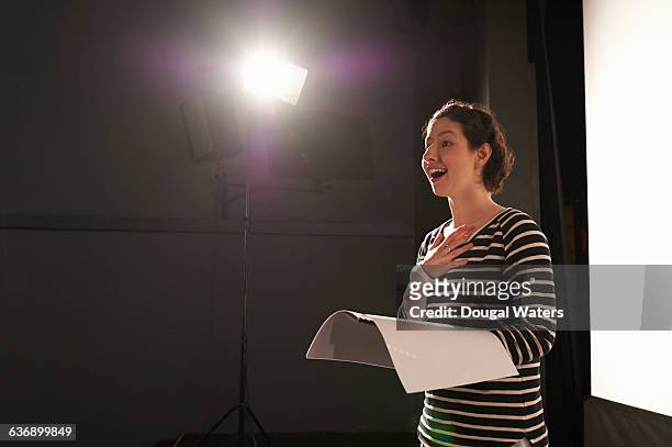 actress rehearsing under spotlight on stage. - best original screenplay fotografías e imágenes de stock