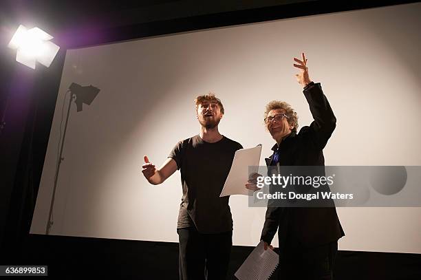 actors rehearsing on stage under spotlight. - acting fotografías e imágenes de stock