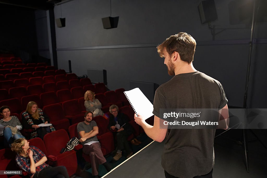 Actor performing on stage to small audience.