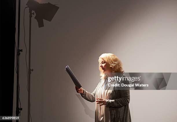 actress rehearsing under spotlight. - schauspielerin stock-fotos und bilder