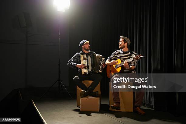 musicians playing on small stage under spotlight. - fisarmonica strumento foto e immagini stock