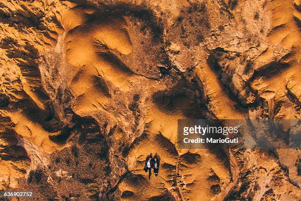 junges paar liegt in der wüste - couple dunes stock-fotos und bilder