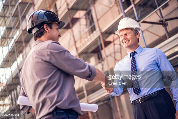 shakehand on a construction site - part of a series stock pictures, royalty-free photos & images