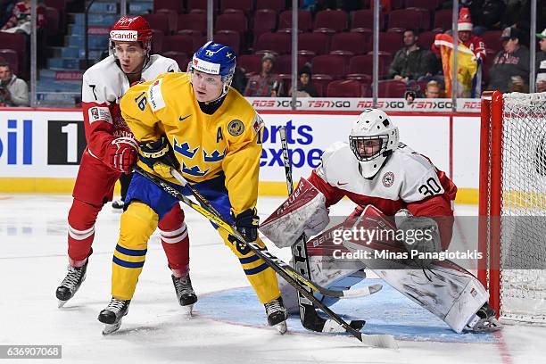 Carl Grundstrom of Team Sweden and Mathias Rondbjerg of Team Denmark battle for position in front of goaltender Lasse Petersen during the IIHF World...