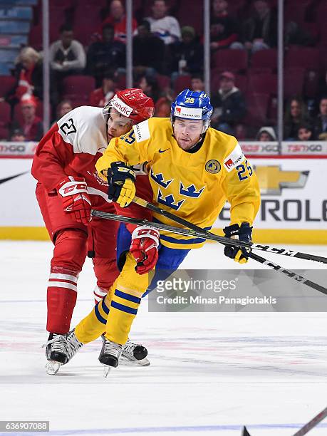 Alexander True of Team Denmark and Sebastian Ohlsson of Team Sweden skate against each other during the IIHF World Junior Championship preliminary...