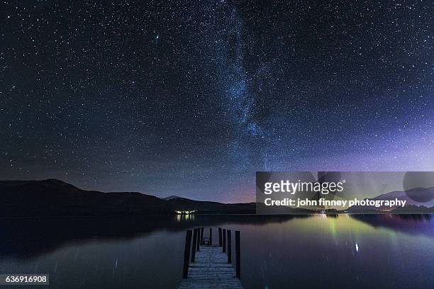 the milky way and aurora borealis from a jetty over derwent water. english lake district. uk - dusk stars stock pictures, royalty-free photos & images