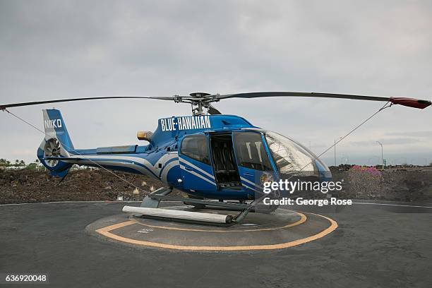 Blue Hawaiian Eurocopter tour helicopter is parked on the Waikoloa landing pad, grounded due to rain and low clouds, on December 17 along the Kona...