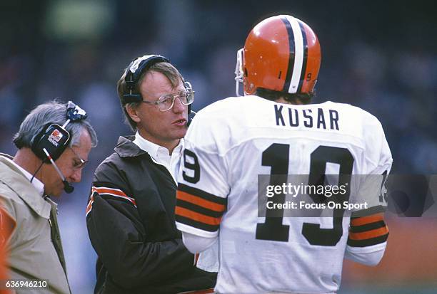 Head Coach Marty Schottenheimer of the Cleveland Browns talks with his quarterback Bernie Kosar during an NFL football game circa 1987 at Cleveland...