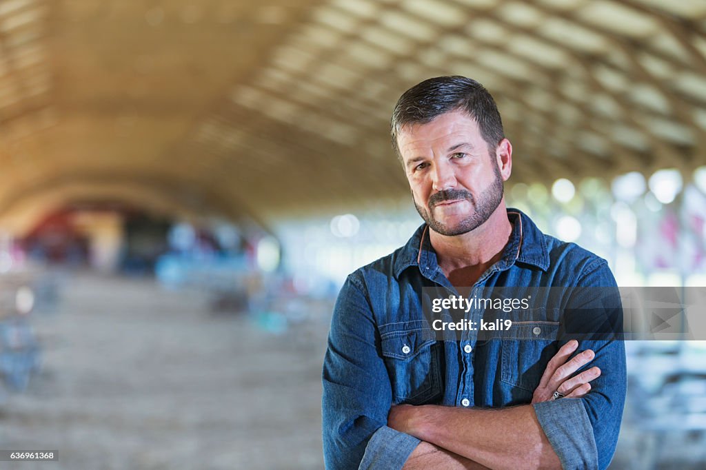 Mature man standing in barn