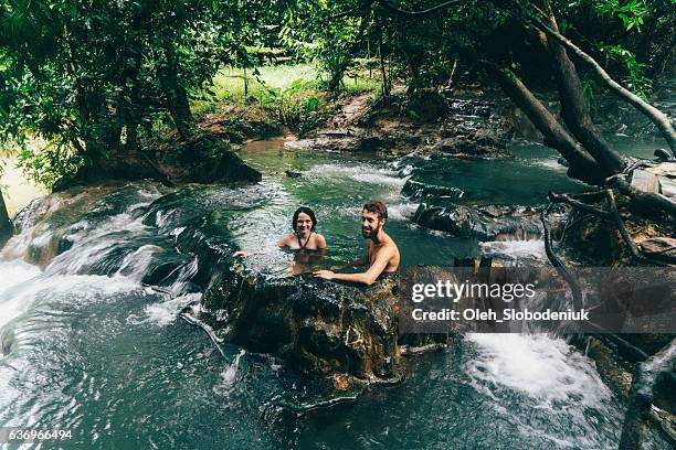 pareja bañándose en cascada de aguas termales - agua estancada fotografías e imágenes de stock