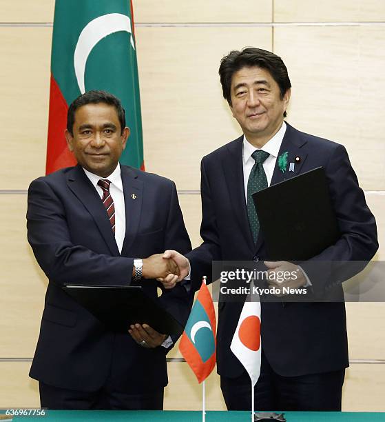 Japan - Maldives President Abdulla Yameen and Japanese Prime Minister Shinzo Abe shake hands after signing a joint statement in Tokyo on April 15,...