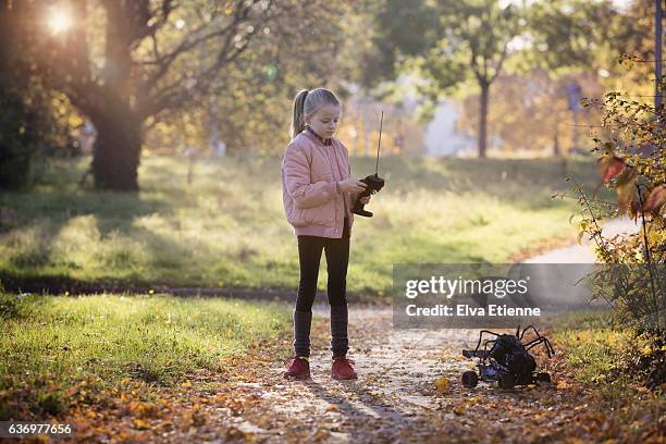 girl playing with remote control toy outdoors - remote control car games stockfoto's en -beelden