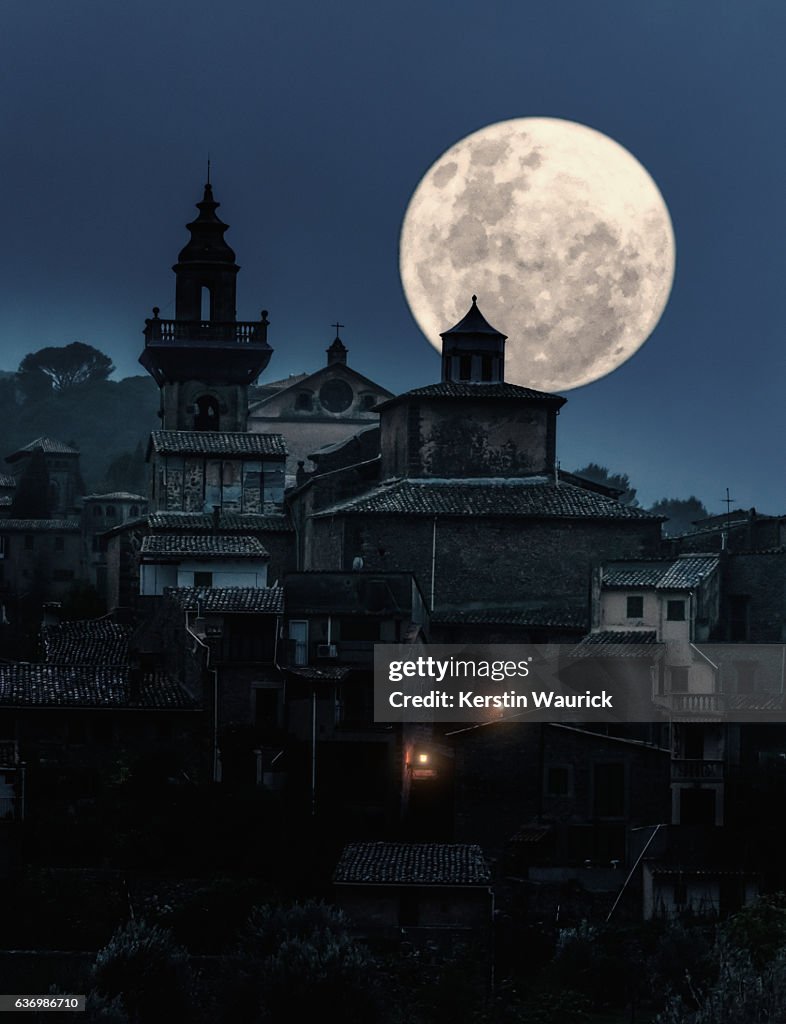 Full moon over medieval village at night