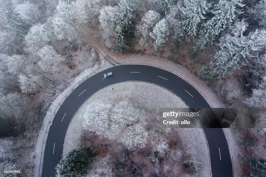 Road curve wintery forest aerial view