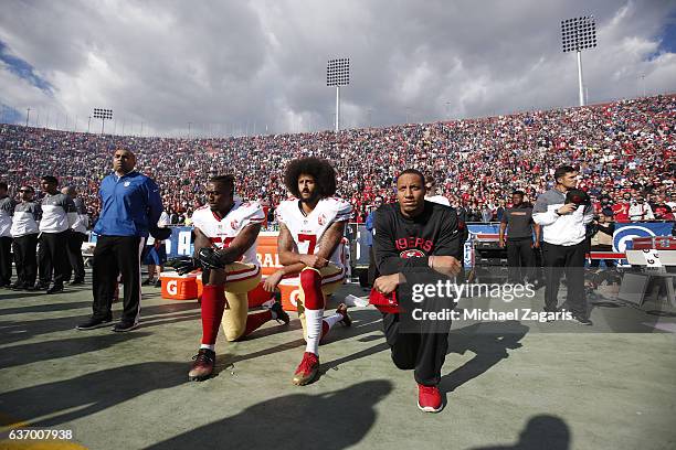 Eli Harold, Colin Kaepernick and Eric Reid of the San Francisco 49ers kneel on the sideline, during the anthem, prior to the game against the Los...