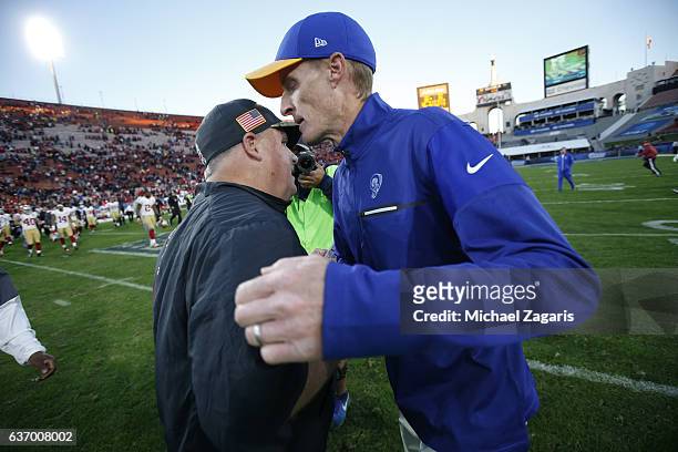Head Coach Chip Kelly of the San Francisco 49ers and Interim Head Coach John Fassel of the Los Angeles Rams embrace on the field following the game...