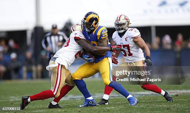 Jaquiski Tartt and Michael Wilhoite of the San Francisco 49ers tackle Lance Kendricks of the Los Angeles Rams during the game at the Los Angeles...