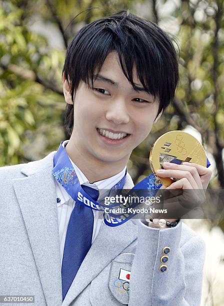 Japan - Sochi Olympic figure skating gold medalist Yuzuru Hanyu holds up his gold medal during a parade in his hometown Sendai, Miyagai Prefecture,...