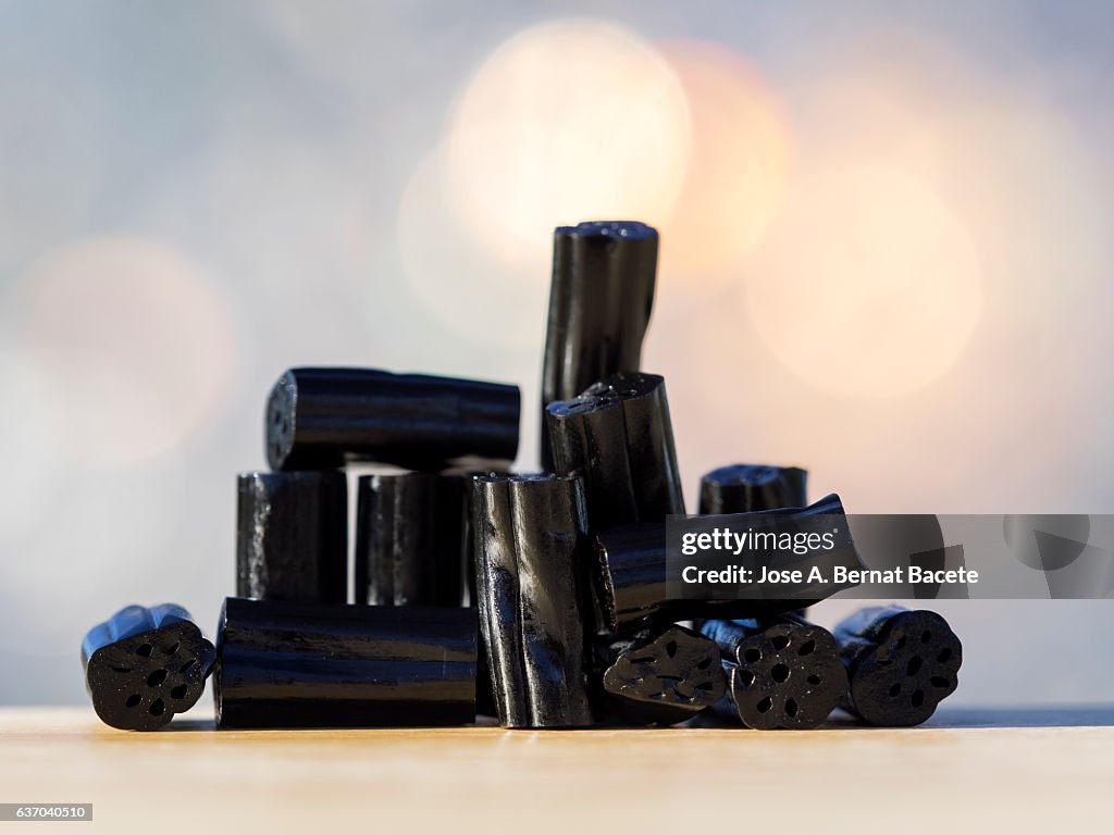 Heap of soft candies of licorice on a table, illuminated by the light of the Sun