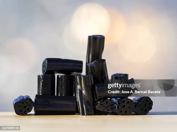 heap of soft candies of licorice on a table, illuminated by the light of the sun - licorice stock pictures, royalty-free photos & images