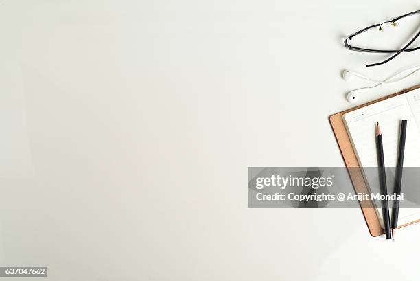 directly above shot of work desk with reading glass, ear phone, notepad and pencil - looking down at desk stock pictures, royalty-free photos & images