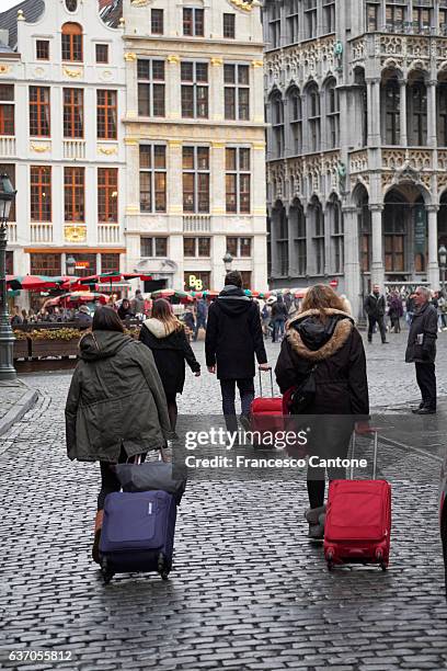 travellers drag their bags - dragging luggage stock pictures, royalty-free photos & images